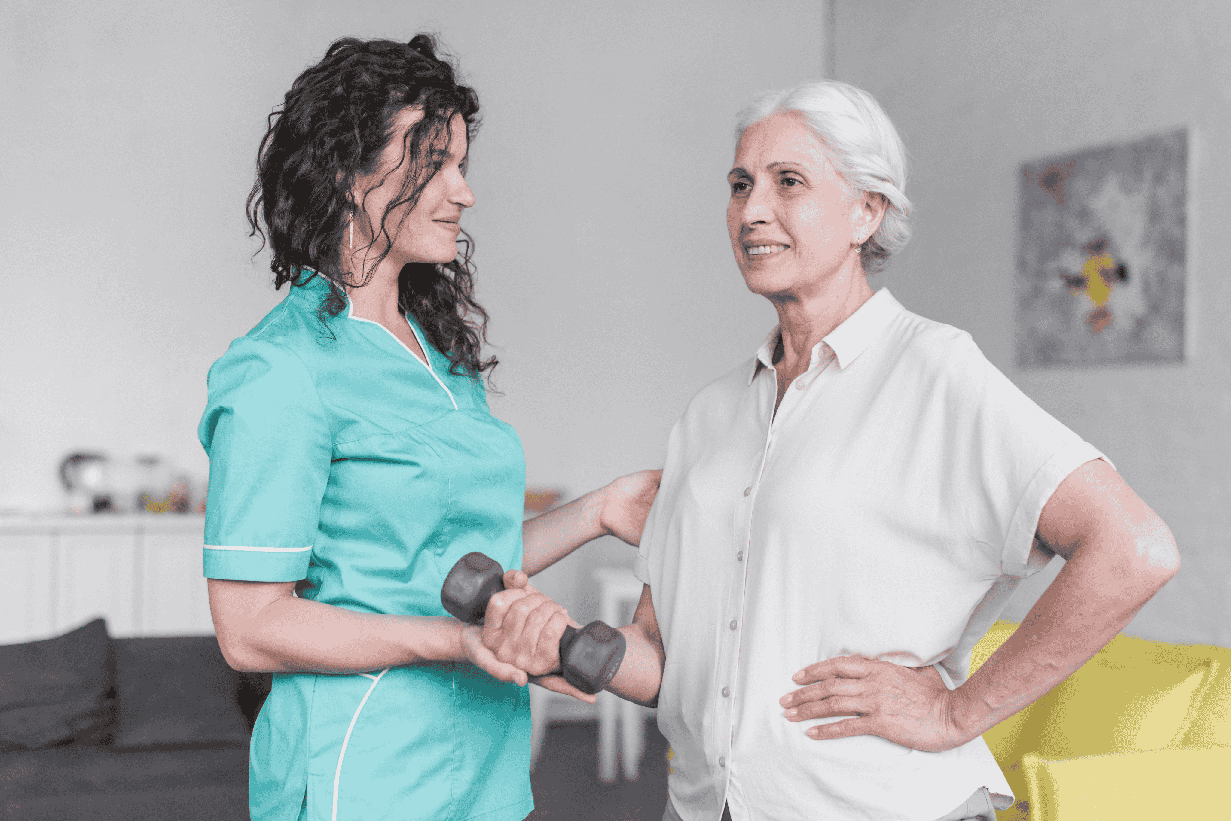 A healthcare provider helping a senior woman with exercise